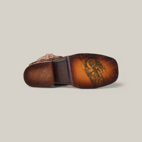 Bottom view of the Asturias Honey Fish Pirarucu Laser & Woven shoe revealing its intricately patterned sole and branding, with a tan and brown embossed Pirarucu leather upper set against a plain background.