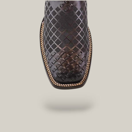 Close-up of the CU676 Over Black Laser & Embroidery & Woven Square Toe Boot, featuring a criss-cross pattern and stitched trim, beautifully contrasted against a plain, light gray background.