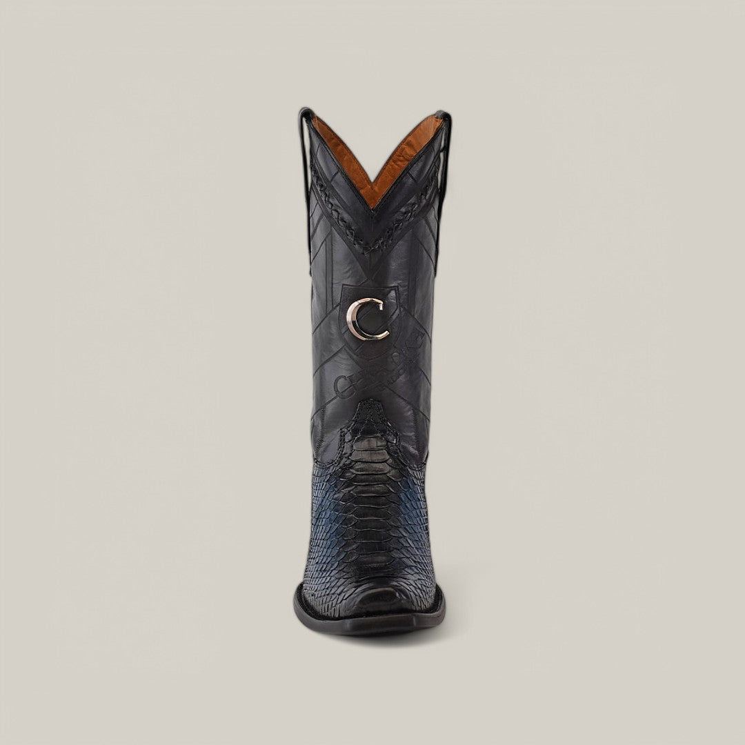 The Cuadra Lisboa Blue Python boot features a striking python pattern with a narrow square toe. A distinct copper buckle etched with a C accents the side, while its shiny texture and tan interior lining enhance its sleek allure.