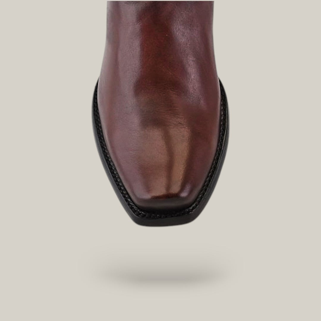 Close-up of an Over Chestnut Laser & Embroidery - Narrow Square Toe (CU347) boot in polished brown leather with black stitching, set against a light gray background.