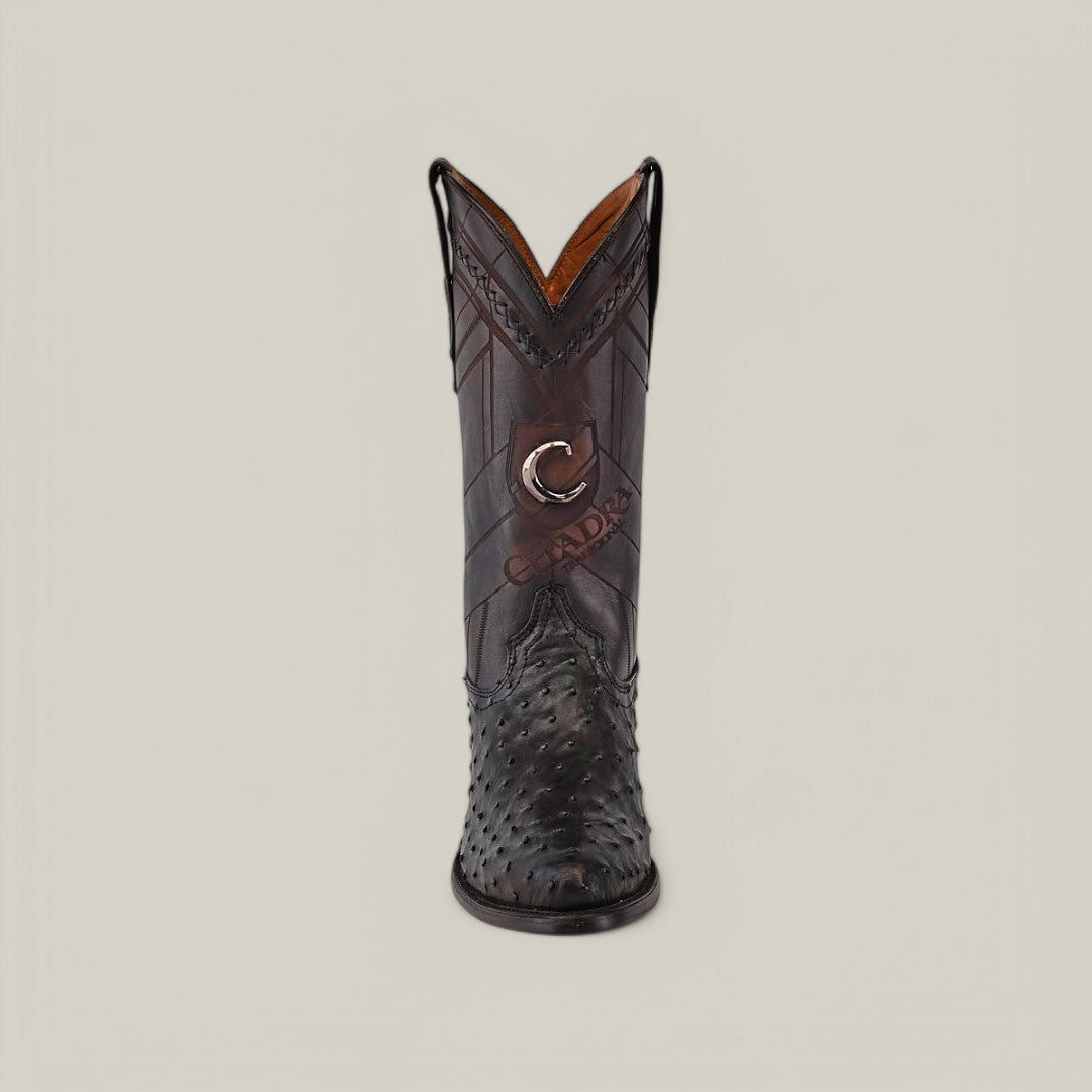 An ornate Cuadra boot, featuring intricate brown leather and textured toe detailing with a C and Cuadra logo on the shaft, mirrors their Black Ostrich Laser & Woven - Round Toe - CU554 style, standing upright against a plain light background.