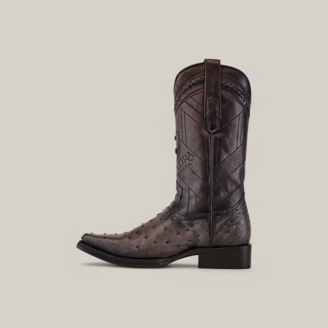 The Everest Gray Ostrich Laser & Woven boot, CU603, is shown in profile on a plain background. It features intricate laser-etched stitching, a low heel, and side pull straps. The boot is made from dark brown ostrich leather with a narrow square toe design.