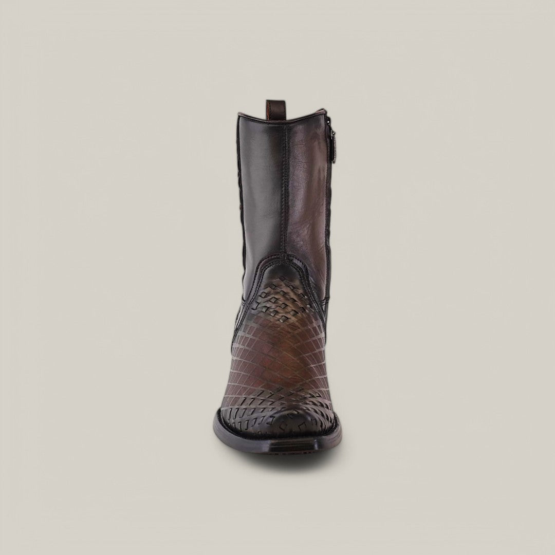 A Cuadra cowboy boot, Over Light Black Laser & Woven - Narrow Square Toe - CU498, with a patterned brown leather surface and black laser detailing, stands on a plain gray background. The mid-calf boot has a narrow square toe and side zipper closure.