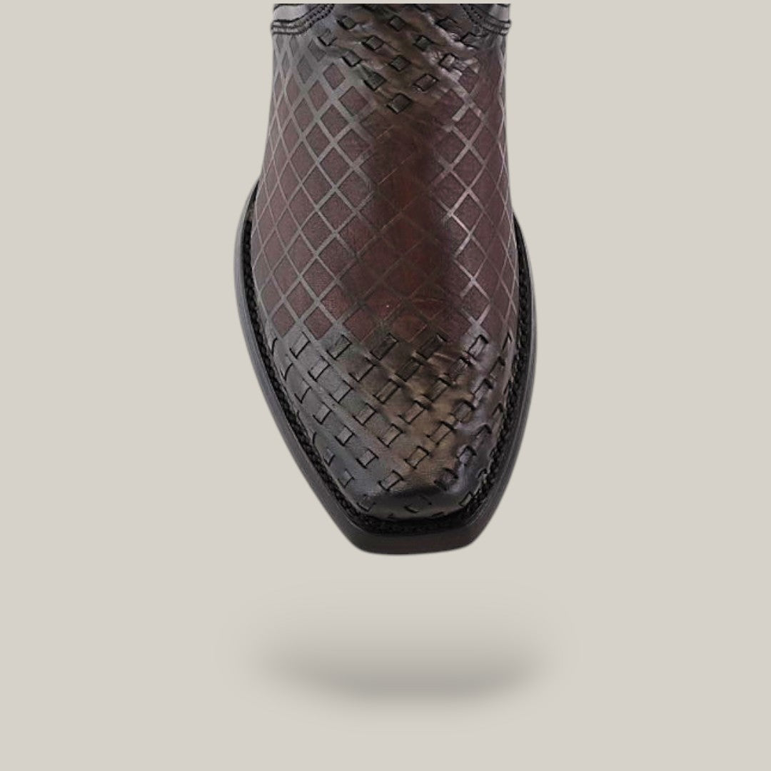 Close-up of an Over Light Black Laser & Woven CU498, a Cuadra shoe with a narrow square toe and textured diamond pattern, against a plain light background.