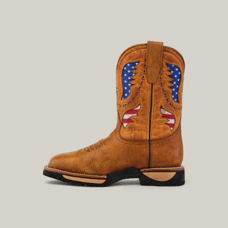 The Taurus Honey Composite Toe - E6189 is a brown cowboy boot inspired by Texas Country Work Boots. It features an embroidered American flag and wing-like design, a durable black sole, tan heel, and practical pull tabs, all set against a light gray background.