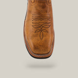 Close-up of the Taurus Honey Composite Toe - E6189, a brown leather Texas Country Work Boot with intricate stitching on the square toe. It features prominent white stitching for durability, shown against a light gray backdrop.