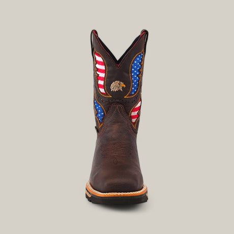 The Taurus Moka Composite Toe - E6189 is a dark brown Texas Country Work Boot featuring red, white, and blue flag patterns on the shaft with an embroidered eagle centered. It has tan welt stitching, a textured sole for durability, set against a plain light gray background.