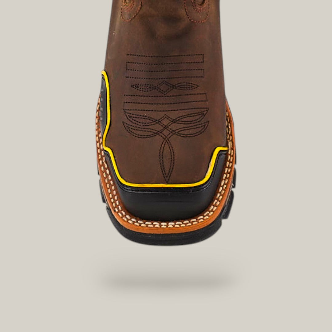 Close-up of the Amazonas Dark Brown Soft Toe - E6256 cowboy boot with a decorative stitch, highlighting its durability. It features a square toe with yellow and black accents and white stitching along the welt against a solid light gray background.