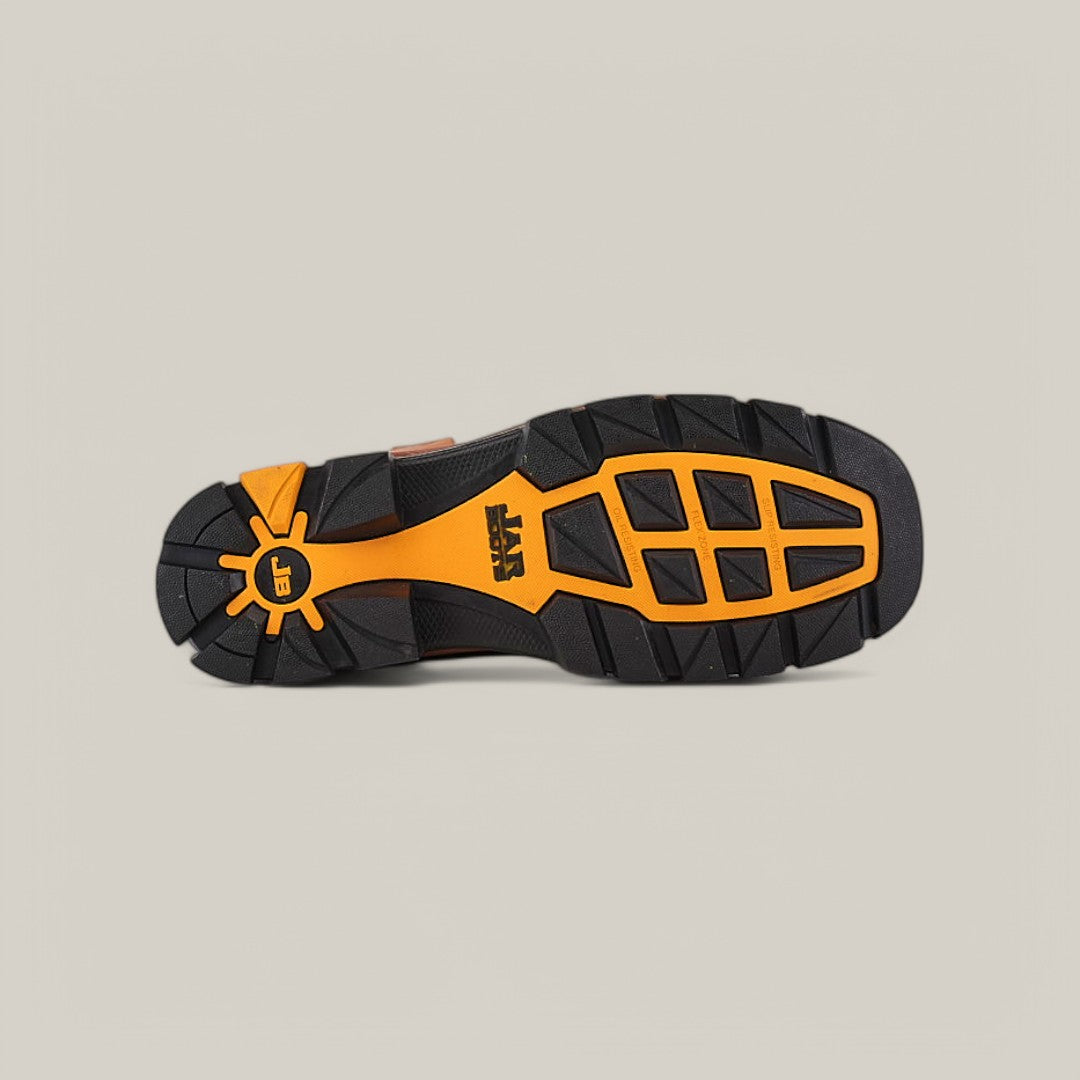 The image displays the sole of the Amazonas Honey Soft Toe - E6002, a durable shoe suitable for Texas Country Work Boots. It has a rugged, textured design with black and orange rubber sections and a bold yellow emblem with a unique symbol at the center on a plain, light background.