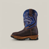 The Amazon Brown Soft Toe - E6002 cowboy boot features a thick sole and intricate blue leather upper stitchwork. Designed for durability and comfort across any terrain, it stands alone on a plain light beige backdrop.