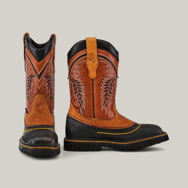 The Crazy Honey Composite Toe - E6048 boots feature intricate brown and black stitch designs. The left boot faces forward, while the right one is angled slightly, showcasing decorative leather patterns and a rugged, sturdy sole suitable for any terrain.