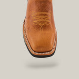 Close-up of the Rino Honey Soft Toe - E6077, a brown leather cowboy boot with intricate yellow stitching on the upper. It sports a square toe and thick white stitching along the sole, embodying Texas Country Work Boots style against a plain light gray background.