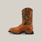 The Alazan Sand Soft Toe - E6081 is a single cowboy boot with a brown leather foot and camouflaged upper, intricate stitching, and a black rubber sole. It offers durable comfort and embodies the rugged spirit of Texas Country Work Boots against a plain background.