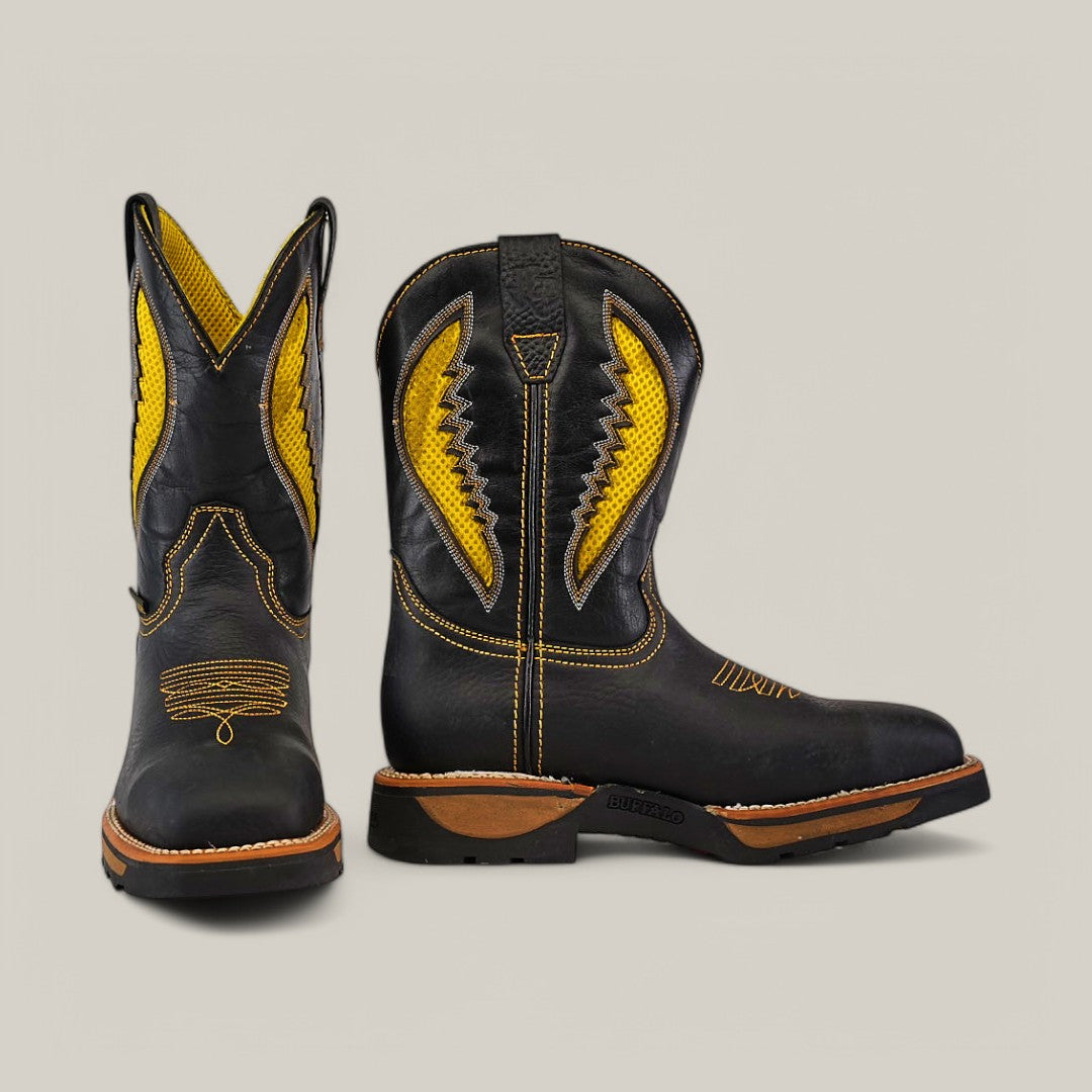 A pair of Rhino Black Soft Toe boots - E6087, features vibrant yellow embroidery and patterns. One boot stands upright with the other slightly tilted, highlighting their intricate design, durable construction, and sturdy soles against a plain background.