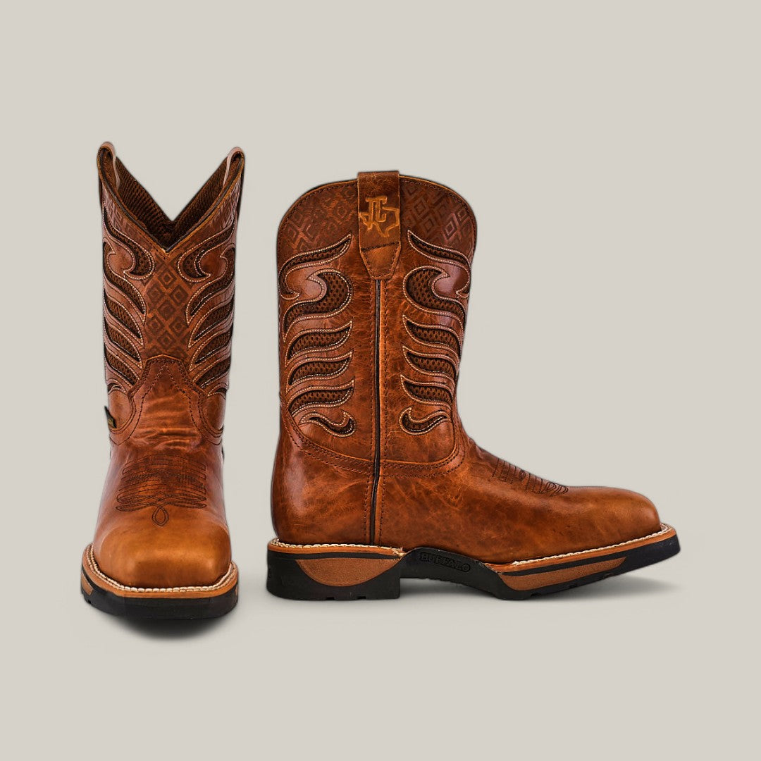 A pair of durable brown leather Crater Honey Composite Toe boots with intricate stitching and decorative designs. One boot is upright showing its side, while the other displays the front. They feature black soles and a light tan shaft with stitched patterns.