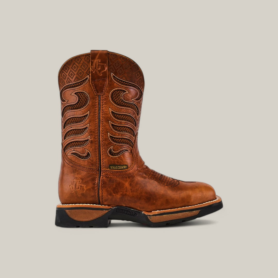 A single Crater Honey Composite Toe - E6087 boot by Texas Country Work Boots features brown leather with intricate stitching and textured shaft design. It has a sturdy black sole for durability and a side tag, set against a plain light gray background.