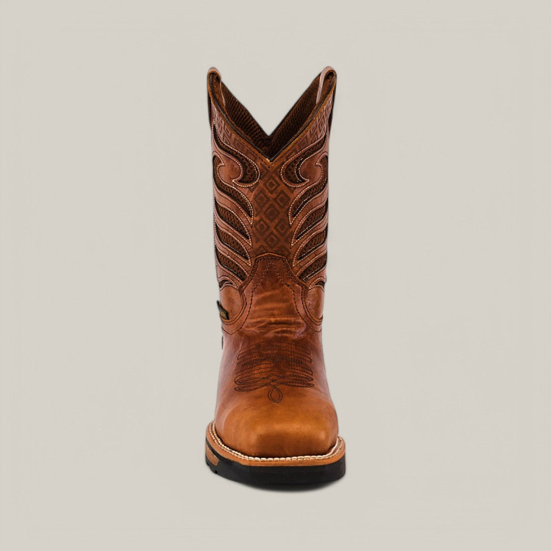 Centered against a plain gray backdrop is a single, intricately stitched brown cowboy boot. This durable Crater Honey Soft Toe - E6087 features a pointed toe and traditional Western design patterns, combining style and strength.