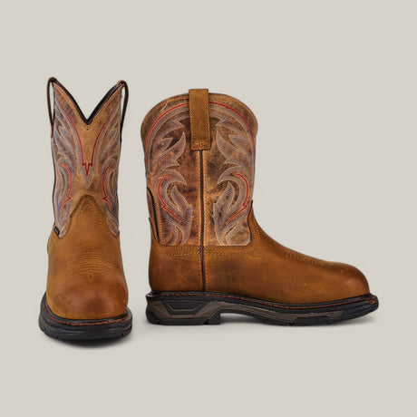 The Workhog Xt H2o Brown boots (model 10045435) feature intricate red and gray shaft stitching, rounded composite toes, and sturdy black soles. Enhanced with waterproof technology, they are beautifully showcased against a plain background.