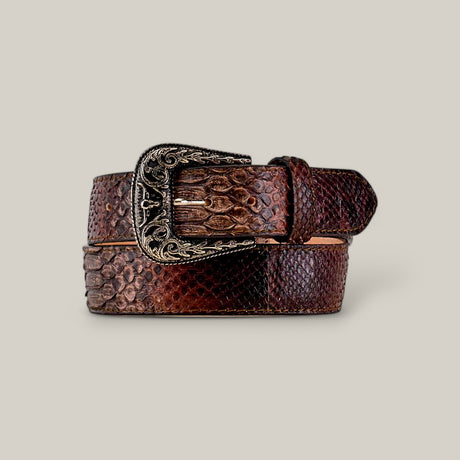 The Exotic Full Quilt Python - Texas Buckle belt is a brown two-colored leather accessory featuring a glossy reptile-like texture and an ornate buckle with intricate gold patterns, set against a plain, light background.