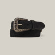 The Exotic Full Quilt Ostrich - Texas Buckle - Matte Black Belt with intricate engravings is coiled on a neutral background, highlighting its luxurious texture.