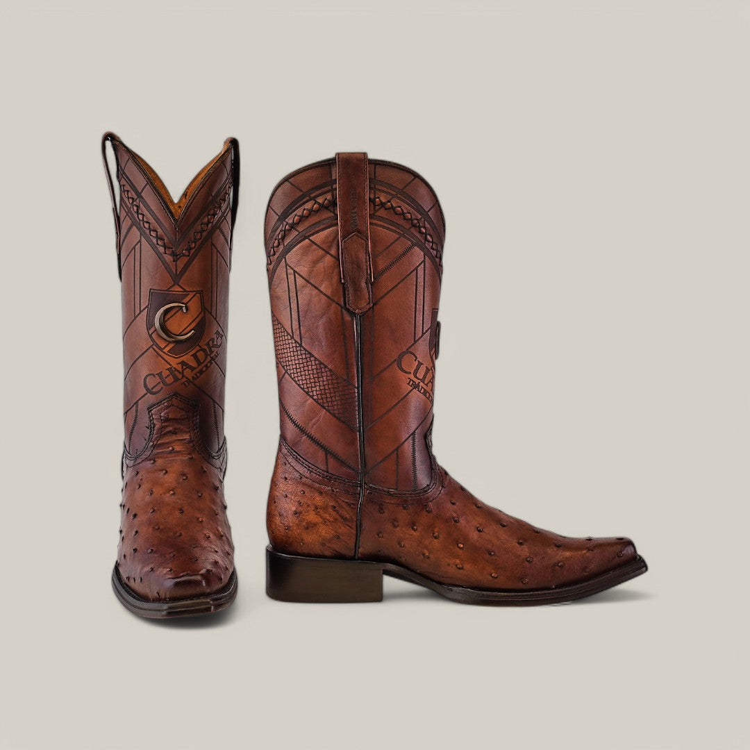 The Arauco Chocolate Ostrich Laser & Woven cowboy boots (CU597) feature intricate laser-engraved patterns and a distinctive logo. The exotic leather showcases a smooth toe with a textured upper section, all set against a plain background.