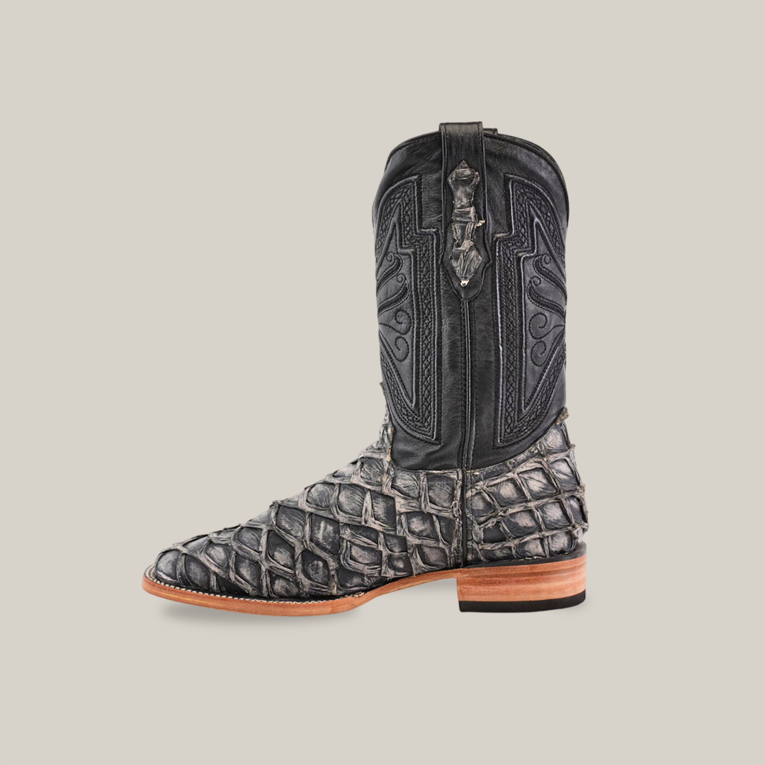 A single Exotic Piraruco Fish boot features intricate shaft patterns, a textured Piraruco-like leather foot, wooden heel, and rustic bone accents on a plain beige background.