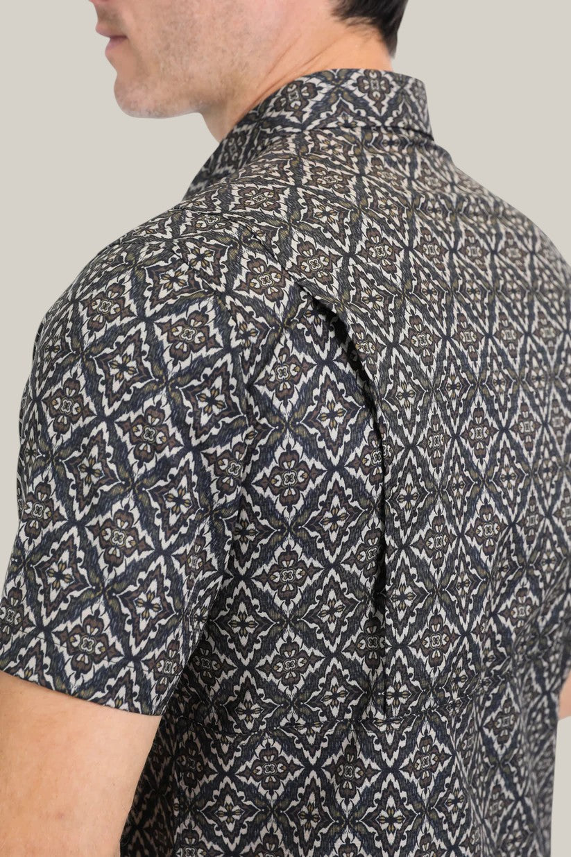 A person in profile wears the Mens Performance Western Short Sleeve Aztec Print Black/Brown Shirt, PGW10635, showcasing a geometric diamond pattern on a light grey background.