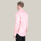 A person with short blond hair is seen from behind wearing the CTL9826 Mens Single Pocket Logo Modern Fit Stretch Dress Shirt in pink and black pants, set against a plain gray background.