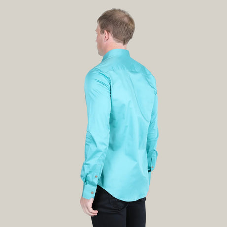 A person with short blond hair stands against a plain background, facing away. They wear a turquoise Men’s Single Pocket Logo Modern Fit Stretch Dress Shirt (CTL9829) paired with black pants, arms relaxed by their sides.