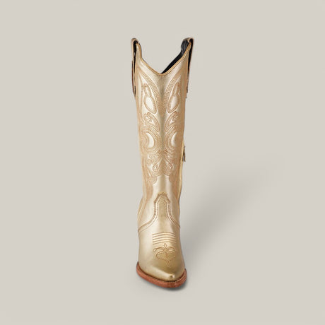 Introducing the Linda Tall Shaft Gold - J Toe boot from the Platinum Collection—this shimmering gold cowboy boot showcases intricate decorative stitching, a J Toe, and a natural brown heel, all set against a plain gray background for effortless style.