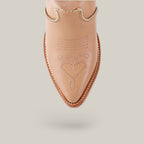 A close-up shows the intricate heart stitching and line details on a tan boot from the Platinum Collection. It features a pointed toe with metal chains around the top edge, similar to the Linda Studs Tall Shaft Cream - J Toe style, against a plain background.