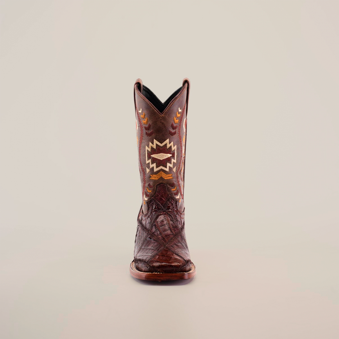 The Exotic American Alligator Patchwork Brown Square Toe boot features a stunning white, yellow, and orange stitch pattern on genuine alligator skin. Its high shaft has intricate embroidery that stands out beautifully against a plain white background.