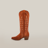 The Caroly Brick Suede Boot stands out with its tall shaft and snip toe, crafted from premium leather in a cowboy style with decorative stitching and white accents against a plain white backdrop.