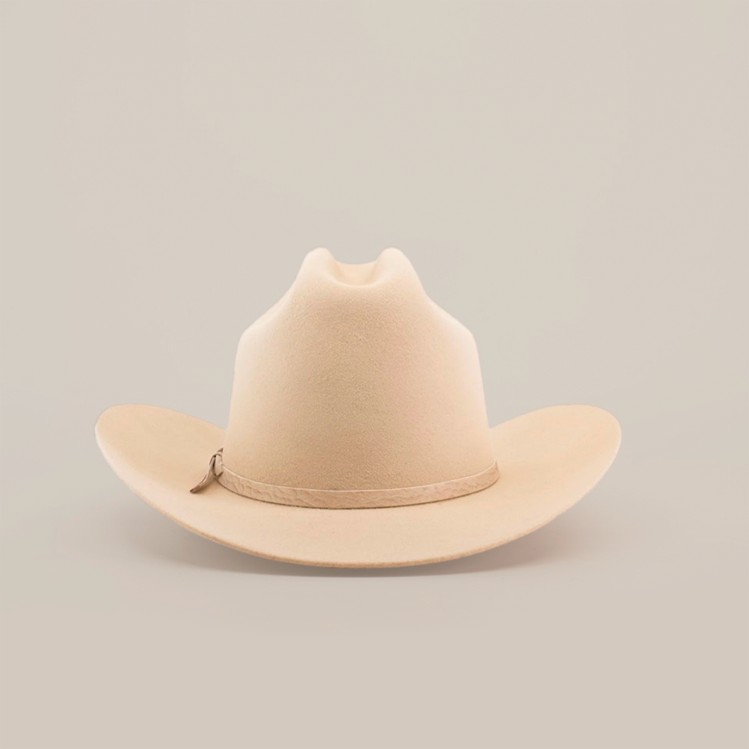 The 6X 2 Carnales Bone, a classic western beige felt cowboy hat with a wide, curved brim and crown crease, is featured against a plain white background.