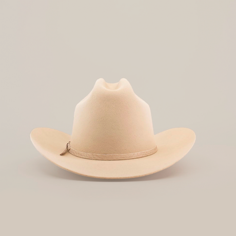 The 6X 2 Carnales Bone, a classic western beige felt cowboy hat with a wide, curved brim and crown crease, is featured against a plain white background.