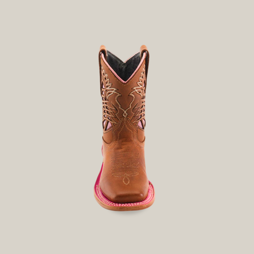 The Dube Tan Pink Outline features a front view of a single brown cowboy boot, expertly crafted with intricate stitching on the shaft. Made from premium handcrafted leather, it has a square toe and red accents on the sole against a plain white background.