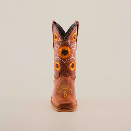 Part of the Sunflowers Tabaco - Square Toe collection, this single cowboy boot highlights superior craftsmanship with intricate yellow and orange sunflower embroidery on the shaft, set against premium brown leather, all viewed on a plain white background.