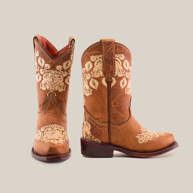 The Martey Crystals Sahara - Snip Toe are elegant brown cowboy boots featuring detailed cream embroidery and crystal embellishments on the shafts and vamps, one displayed facing forward and the other in profile.