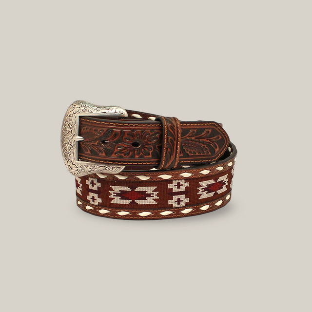 The Nocona Mens Belt, N210002702, is a brown leather accessory with an ornate silver buckle featuring engraved floral designs. It showcases sophisticated Aztec stitch and whipstitching patterns, exuding Western elegance.