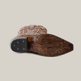 A Rania Copper Tall Shaft boot with intricate sole patterns and a snip toe design is seen lying on its side against a plain background, highlighting detailed craftsmanship.