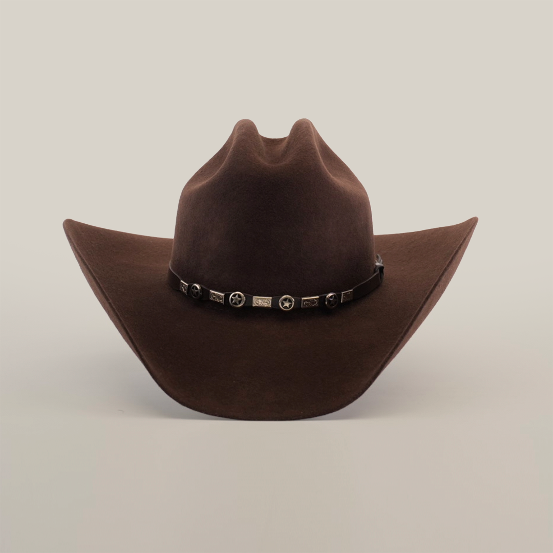 The 6X Country Brown is a Western classic felt cowboy hat made from premium sheep wool. It has a wide brim, pointed crown, and is adorned with a decorative black band featuring silver star accents on a plain white background.