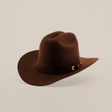 The 6X 2 Carnales Brown cowboy hat features a wide brim and decorative band, crafted from felt, set against a white background.