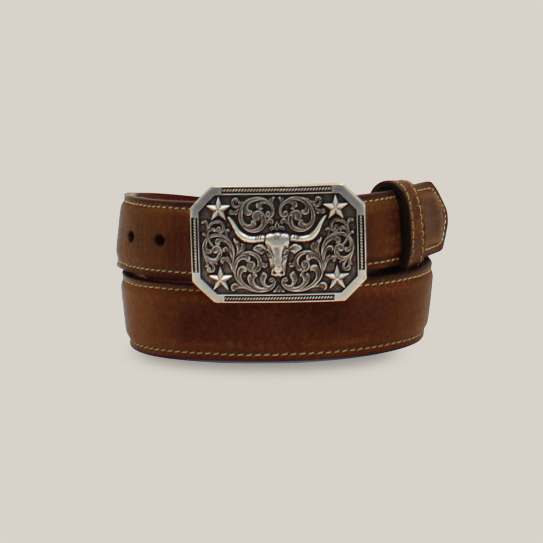 The Nocona Western Boys Belt features a brown leather design with a decorative silver buckle. The buckle showcases intricate floral engravings, a longhorn head design, star accents, and rounded corners, perfect for those seeking unique Western-inspired leather accessories.