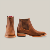 Two Avejentado Honey square toe leather ankle boots are shown, one facing forward and the other in profile. Featuring elastic side panels with texture, a wooden sole, and contrasting red lining for flair—perfect for any relaxed cowboy look.