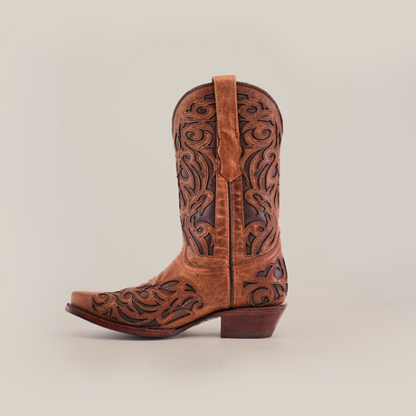 The Trivia Orix - Short Shaft - Snip Toe is a brown womens cowboy boot, handcrafted from premium leather. It features intricate swirls and floral motifs on a plain white background, complete with a low heel and pull straps.