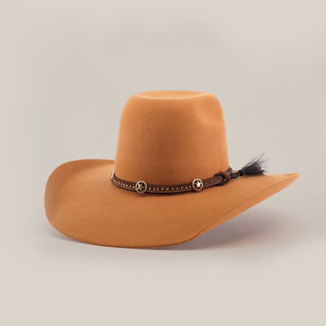 The 6X Brazil Fawn is a wide-brimmed, brown cowboy hat made from Brazil felt. It features a premium leather band with star-shaped ornaments and a feather, all against a plain white background, highlighting its stylish design.