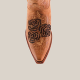 Close-up of the Rosal Fawn Mid Shaft Snip Toe boot, made from premium leather. This brown cowboy boot features black rose embroidery and intricate swirling patterns. Handcrafted stitching around the sole adds elegance and a refined design to its pointed-toe silhouette.