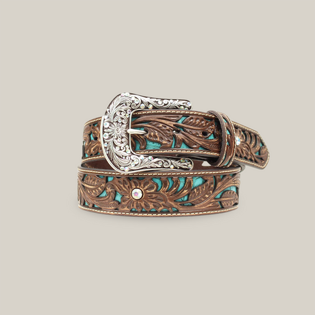 The Ariat Western Womens Belt, model A1513402, is a brown leather belt featuring intricate floral embossing, a detailed silver buckle, turquoise inlays, rhinestone embellishments, and a western style that showcases its artistic craftsmanship.