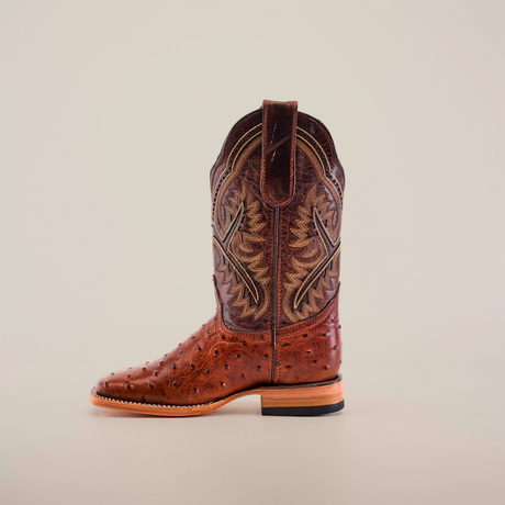 The Karoo Ostrich Print Chocolate Square Toe is a single brown cowboy boot made from premium materials with detailed stitching and a textured pattern. It features a sturdy heel and a pull tab at the top, all set against a plain white background.