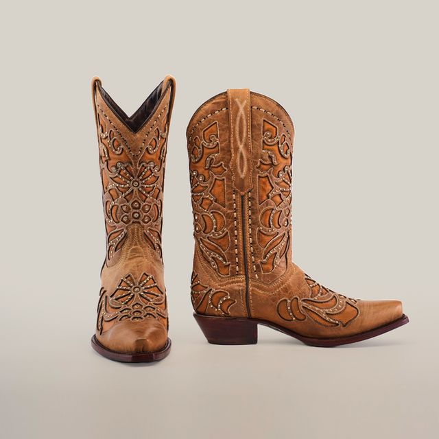 The Cotulla Fawn Crystals boots showcase luxury craftsmanship with intricate stitching and detailed embroidery on the short shaft and snip toe, set against a plain white background; one boot tilts forward slightly, highlighting their low heel—true icons of Western fashion.